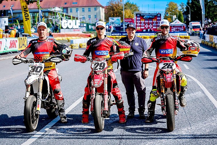 SuperMoto of Nations 2026, St. Wendel Das deutsche Supermoto-Seniorenteam mit seinen drei Fahrern und Teammanager Heiko Junge steht mit den Rennmotorrädern auf der Strecke.