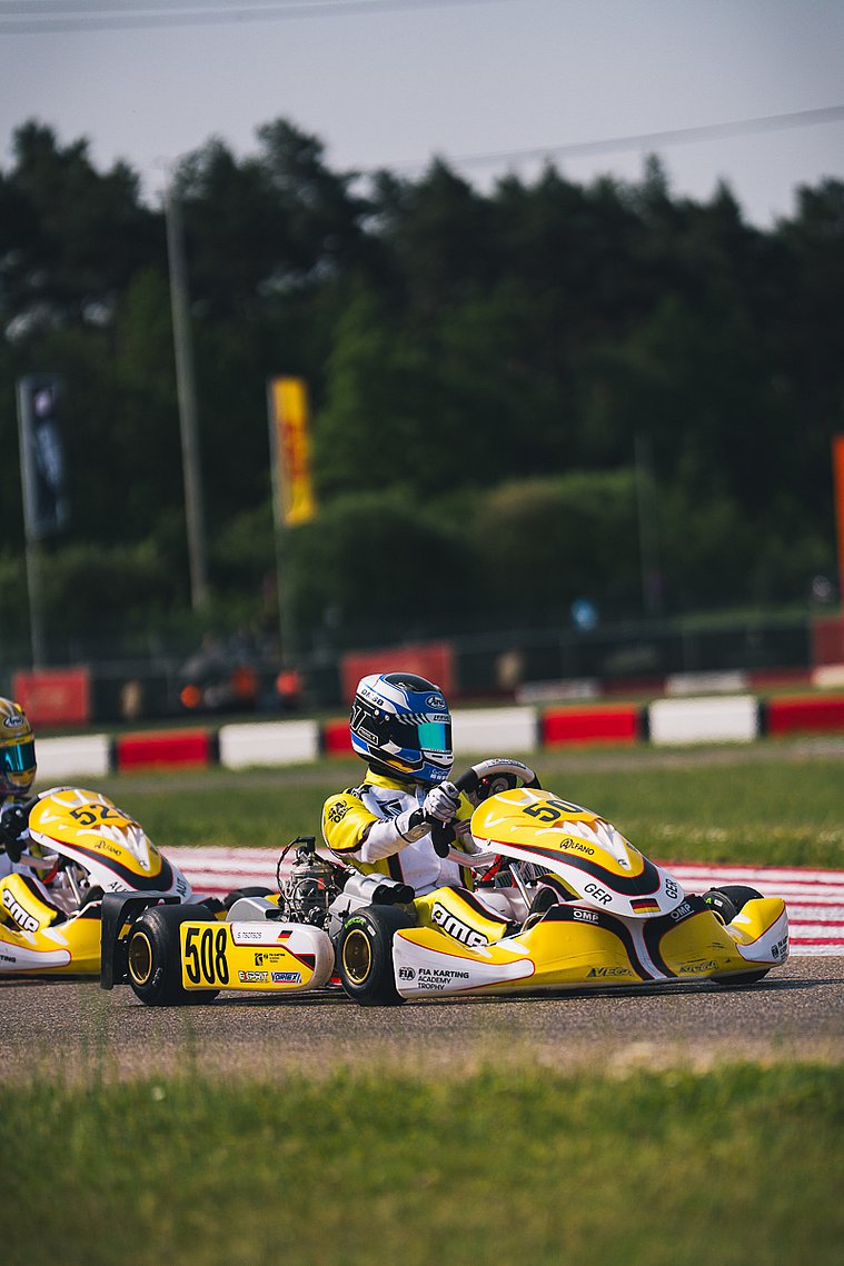 Stavros Tsotsos Francia, FIA Karting Academy Trophy Junior, Genk 2026 Gelbes Kart von Stavros Tsotsos Francia im Rennbetrieb der FIA Karting Academy Trophy, mit Konkurrenten im direkten Umfeld.