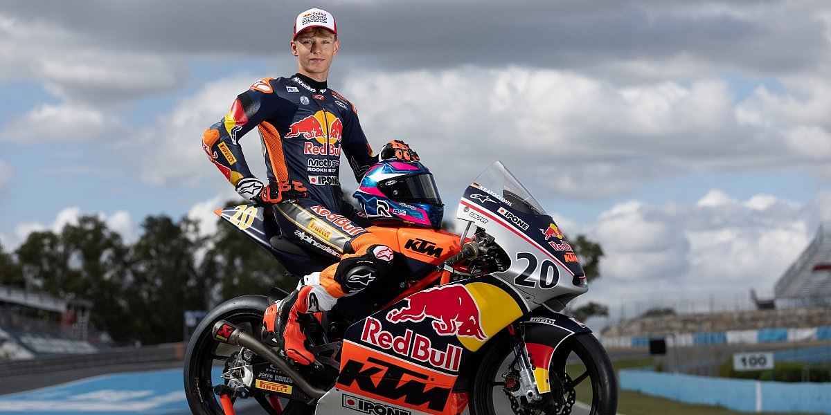 Fynn Kratochwil, Red Bull MotoGP Rookies Cup 2026 Fynn Kratochwil posiert in Rennkleidung neben seinem KTM-Rennmotorrad mit der Startnummer 20 auf einer Rennstrecke.