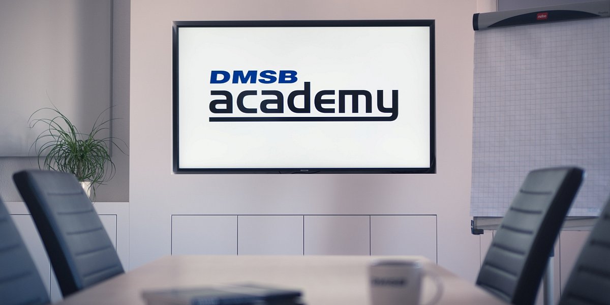 DMSB Academy Schulungsraum Seminarraum mit Tisch und Stühlen, DMSB Academy Logo auf TV angeworfen