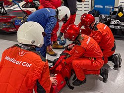 DMSB Medical Days 2026 DMSB Medical Days 2026: Team in roten/blauen Overalls und Helmen kniet an roter Tasche, in der eine Person geborgen wird.