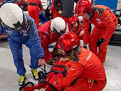 DMSB Medical Days 2026 DMSB Medical Days 2026: Team in roten/blauen Overalls und Helmen kniet an roter Tasche, in der eine Person geborgen wird.