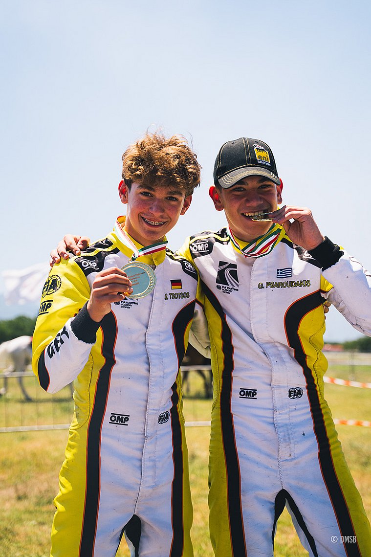 Stavros Tsotsos Francia, FIA Karting Academy Junior-Trophy 2026, Circuito Internazionale Napoli Zwei junge Kartfahrer in weiß-gelb-schwarzer Rennbekleidung stehen nebeneinander und zeigen glücklich ihre Medaillen.