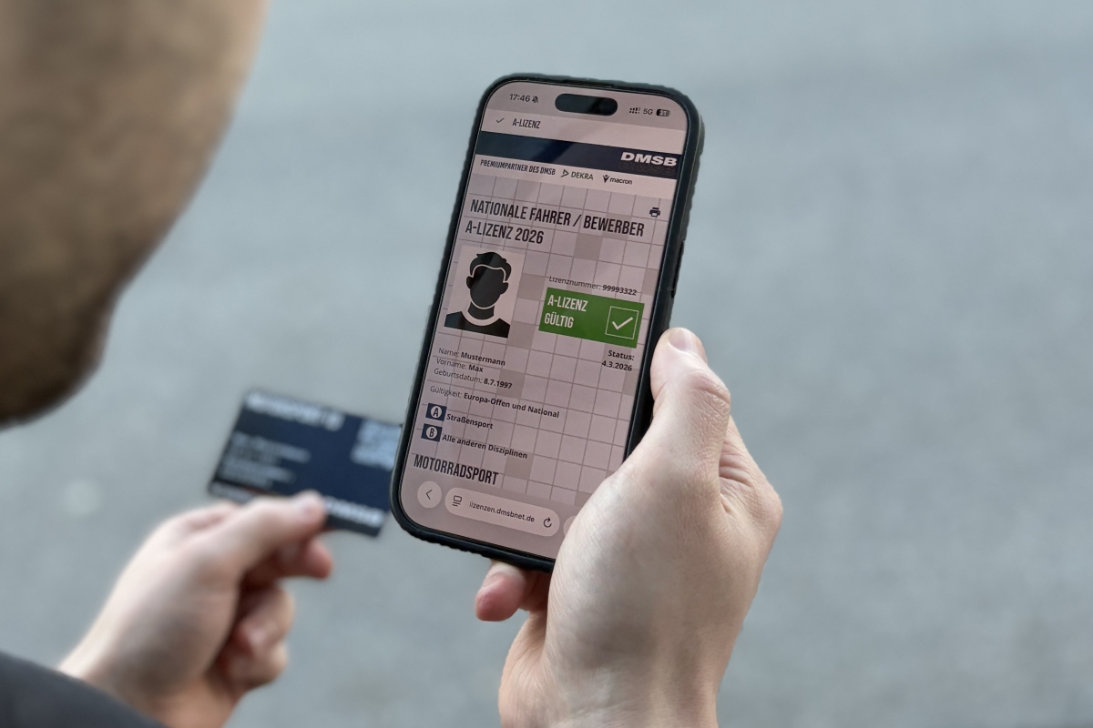 Digitale Lizenz & Motorsport-ID 2026 Mann mit Smartphone, auf dem eine digitale, gültige Fahrerlizenz des DMSB aufgerufen ist. In der Hand im Hintergrund hält er seine Motorsport-iD.