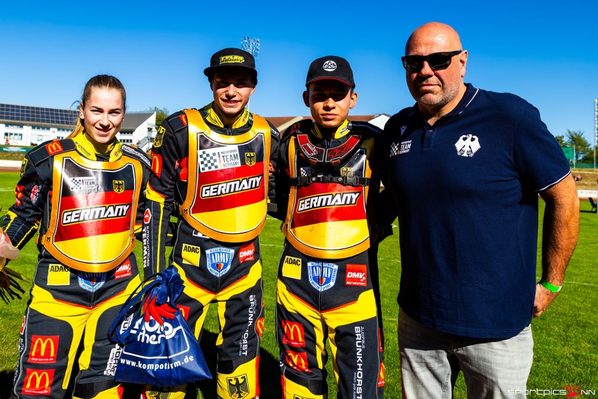 Das deutsche Speedway-Team mit Hannah Grunwald, Tayler Haupt, Patrick Hyjek und Teammanager Sascha Dörner posiert fürs Foto auf einer Rennstrecke.
